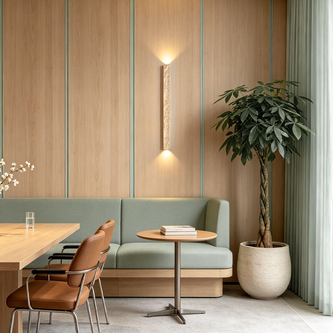 Up down lighting wall sconce installed beside a sofa with warm upward and downward illumination.