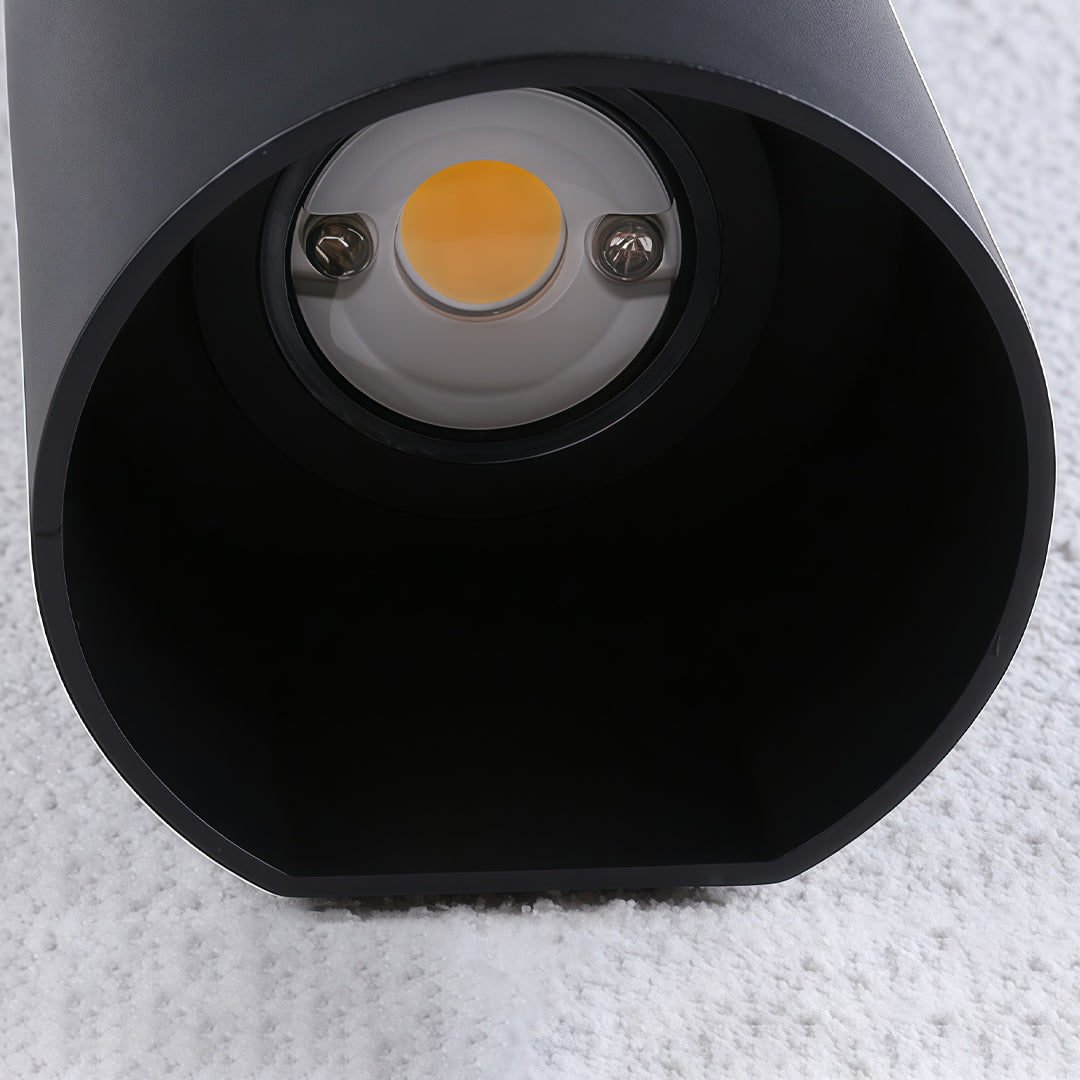 Close-up of up down wall light LED source inside black cylindrical outdoor fixture housing.