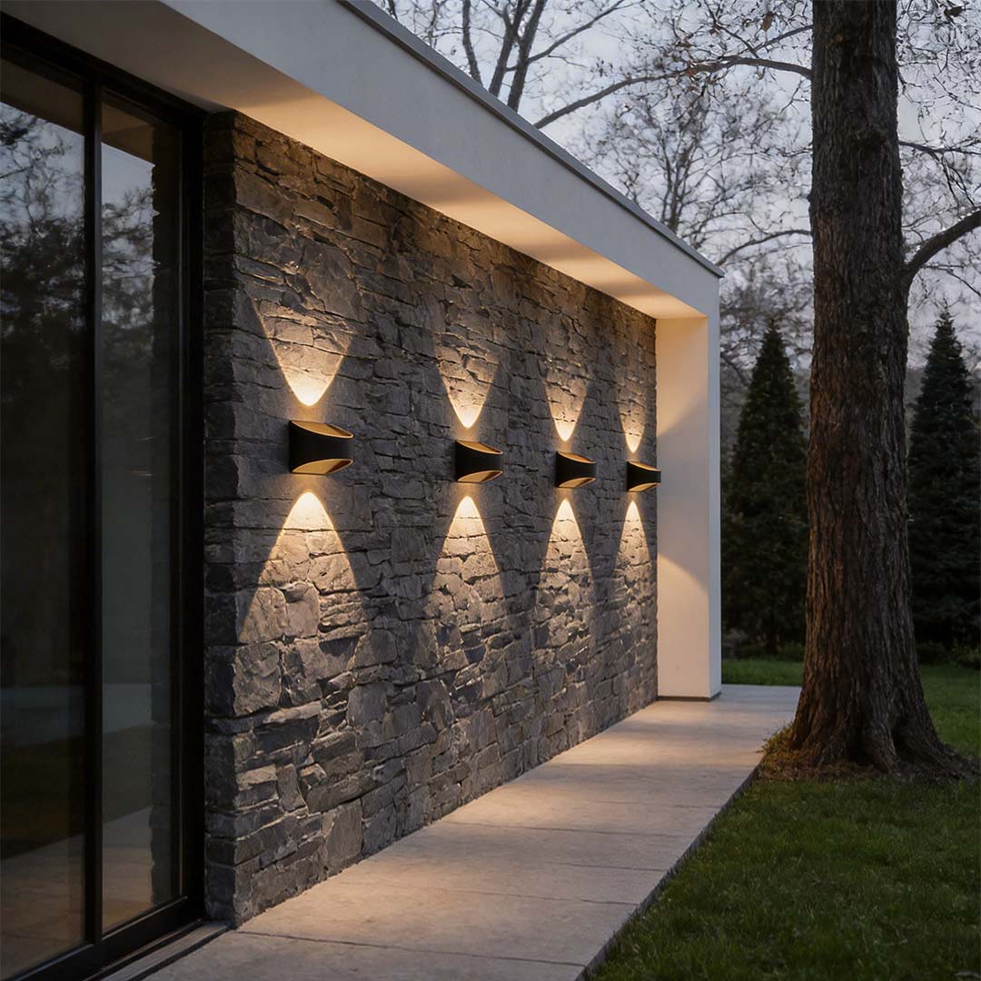 Up and down wall sconce lighting highlighting a stone wall pathway with warm, directional light.