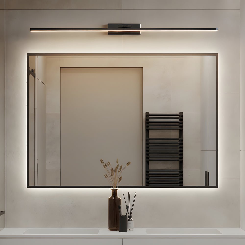 Modern bathroom mirror illuminated by slim black vanity LED lights for mirror, creating soft and even lighting above a rectangular wall mirror.