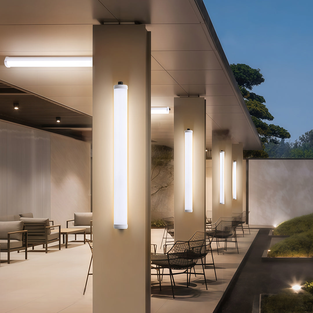 Vertical outdoor wall lighting modern fixtures casting an ambient glow on the pillars of a covered patio.