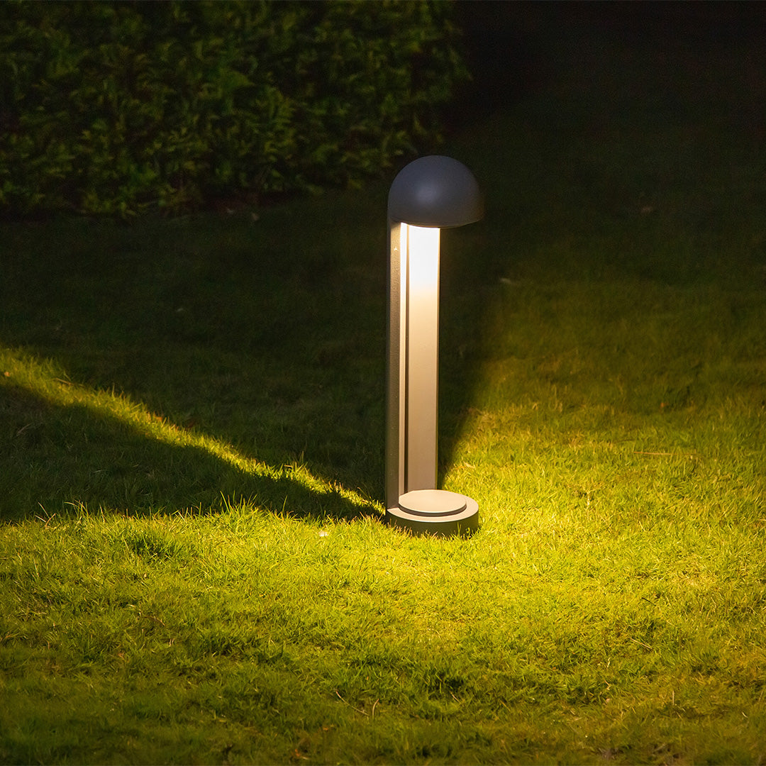 Cylindrical bollard base with vertical light slot for directional illumination output