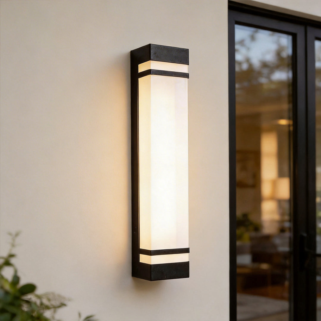 Vertical wall lighting close-up showing a slim rectangular fixture with black trim and a softly glowing diffuser.