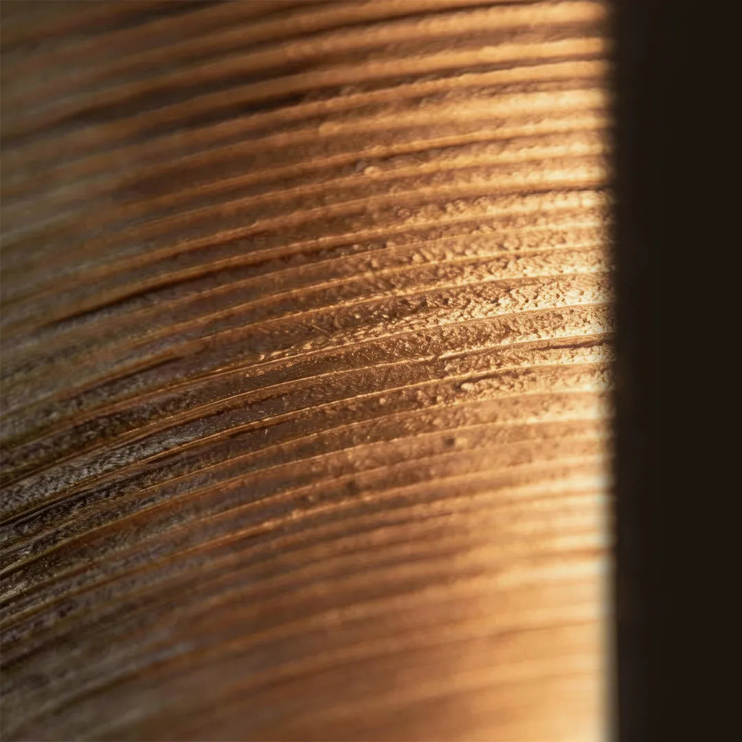 Vertical wall sconce with textured bronze finish and warm ambient lighting