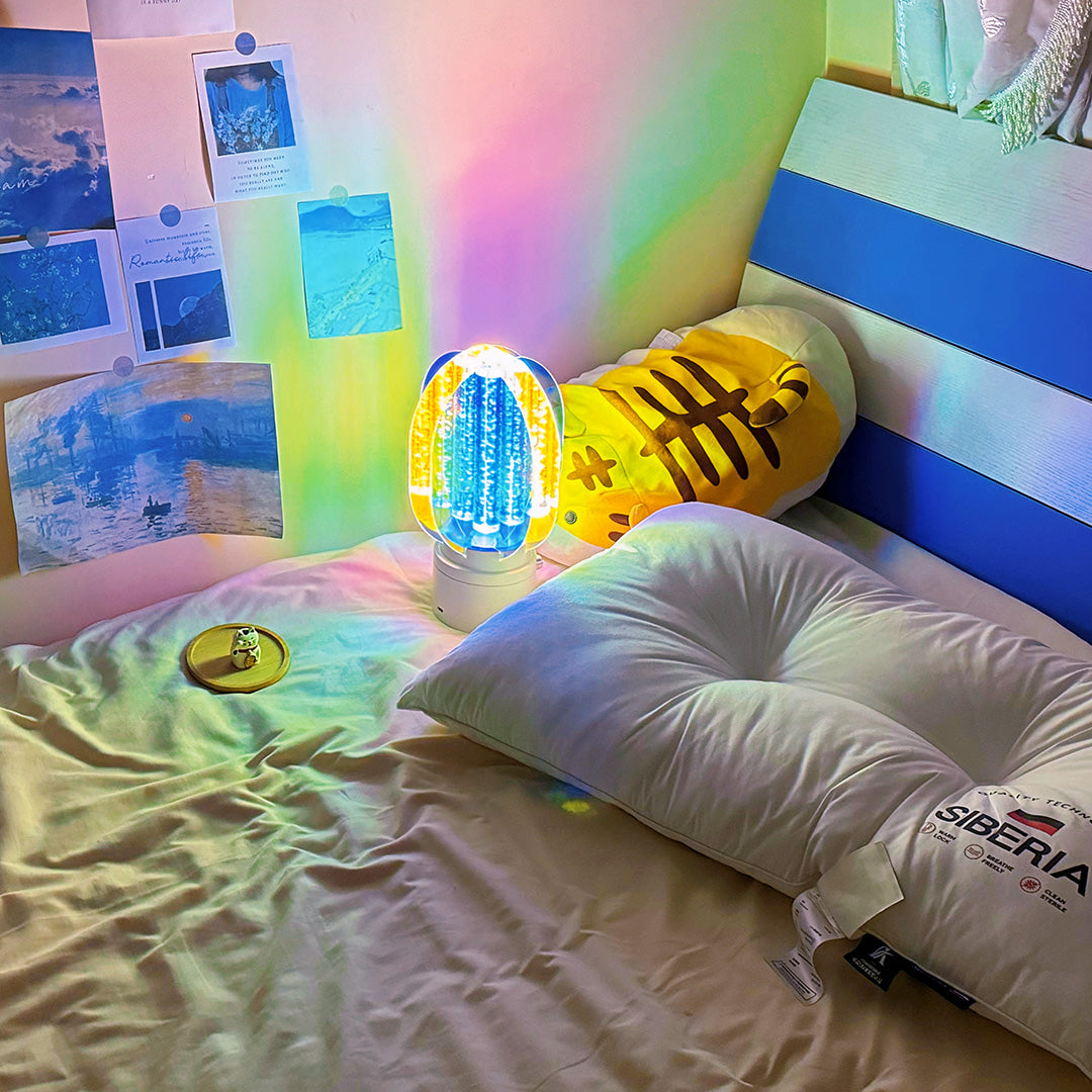 Colourful table lamp sitting on a bedside table, creating a vibrant multi-hued light show in a cozy, dark setting.