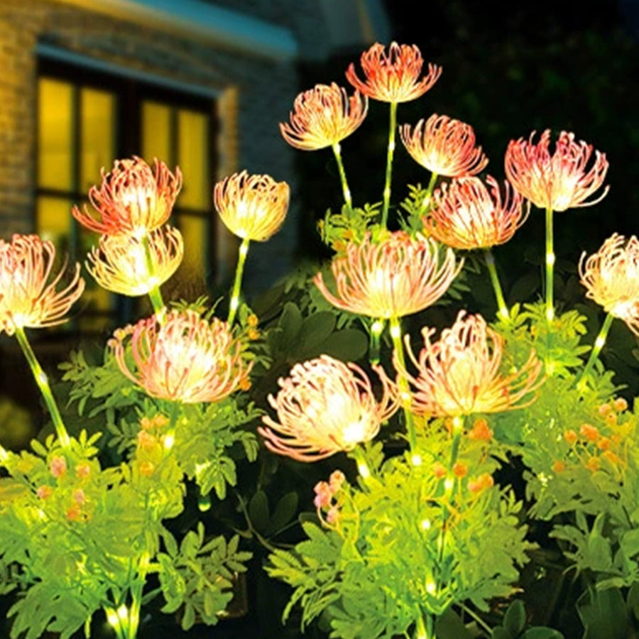 Vibrant solar flower lights creating magical ambiance with yellow and pink blooms in garden setting