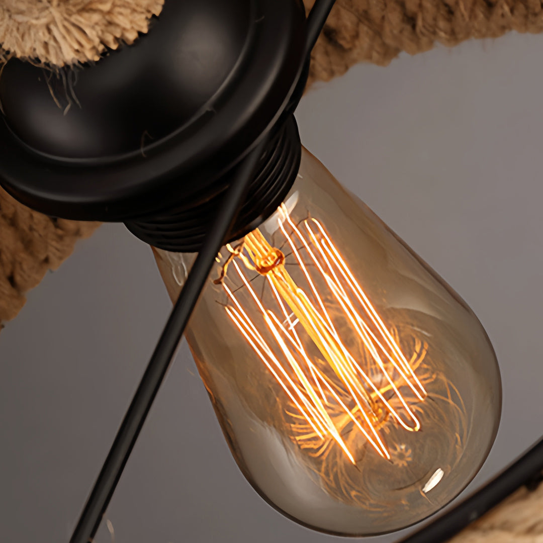 View from below the industrial rope pendant lights showcasing the black metal socket and an exposed vintage Edison bulb.
