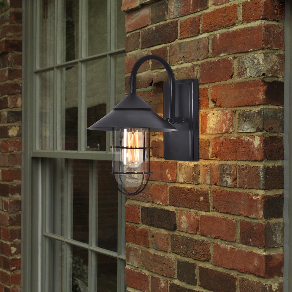 Black barn wall light with vintage design, mounted on a rustic brick wall for a classic outdoor look.