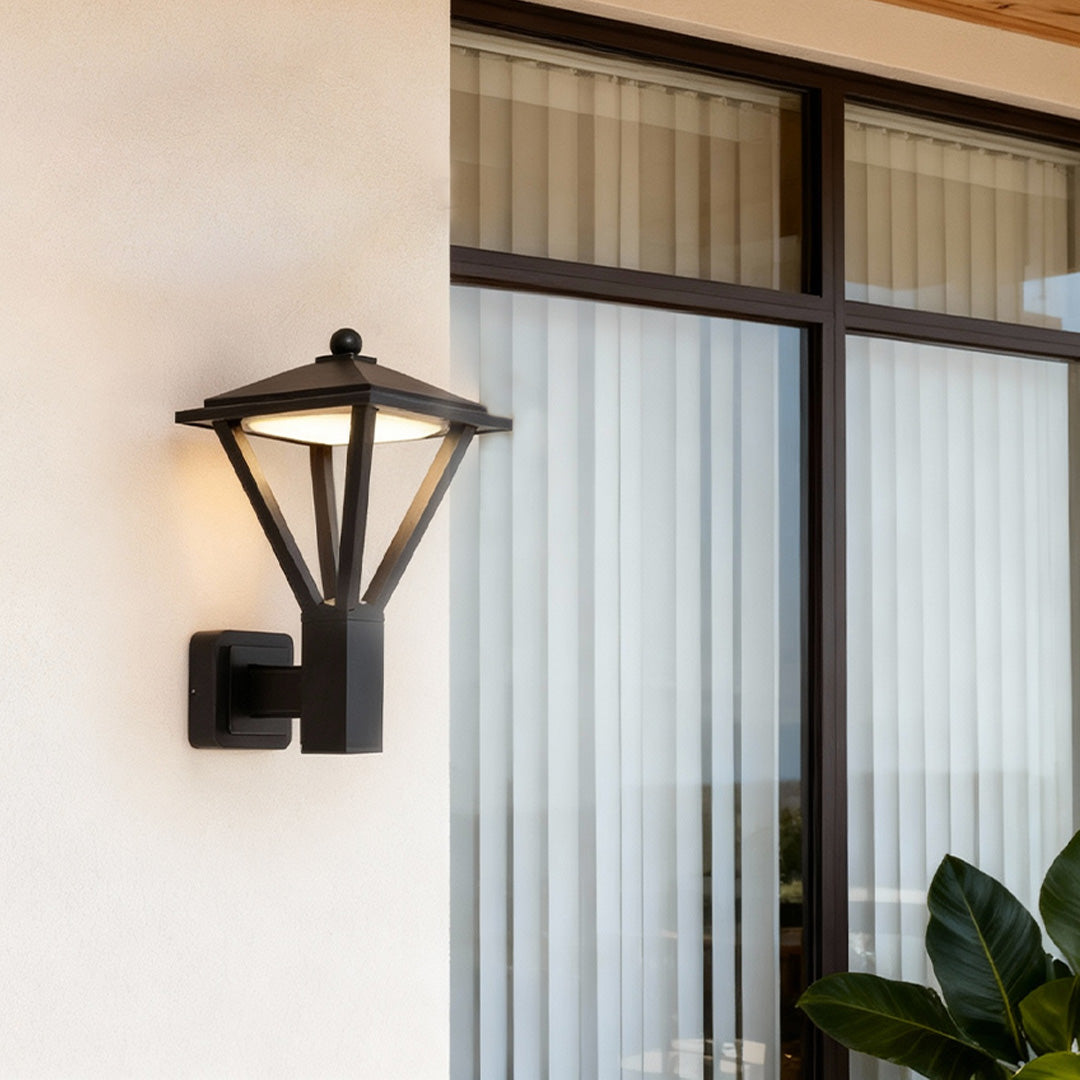 Black vintage outdoor lantern attached beside large windows, providing warm lighting and demonstrating timeless wall mounted lights outdoor.