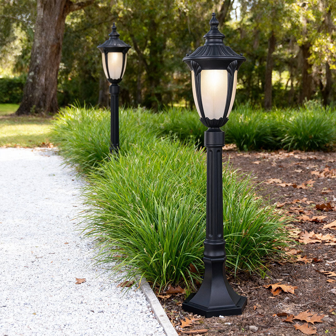 Vintage-style bollard light illuminating a garden pathway, warm and inviting outdoor lighting