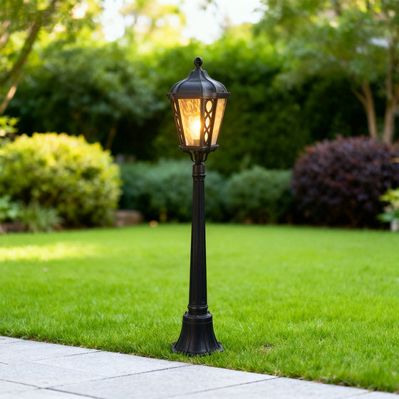 Vintage-style bollard light in a lush garden, warm and inviting outdoor lighting