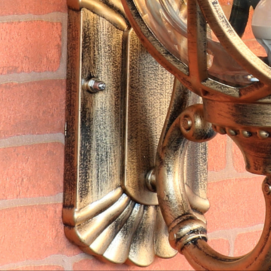 Vintage brass nautical wall lantern with ornate mounting bracket on brick exterior wall