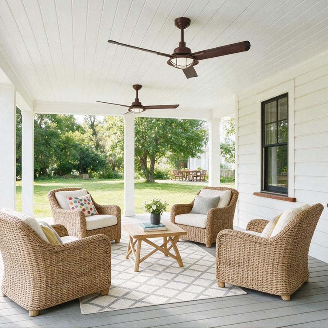Vintage ceiling fans with lights mounted on a bright white porch above wicker seating.