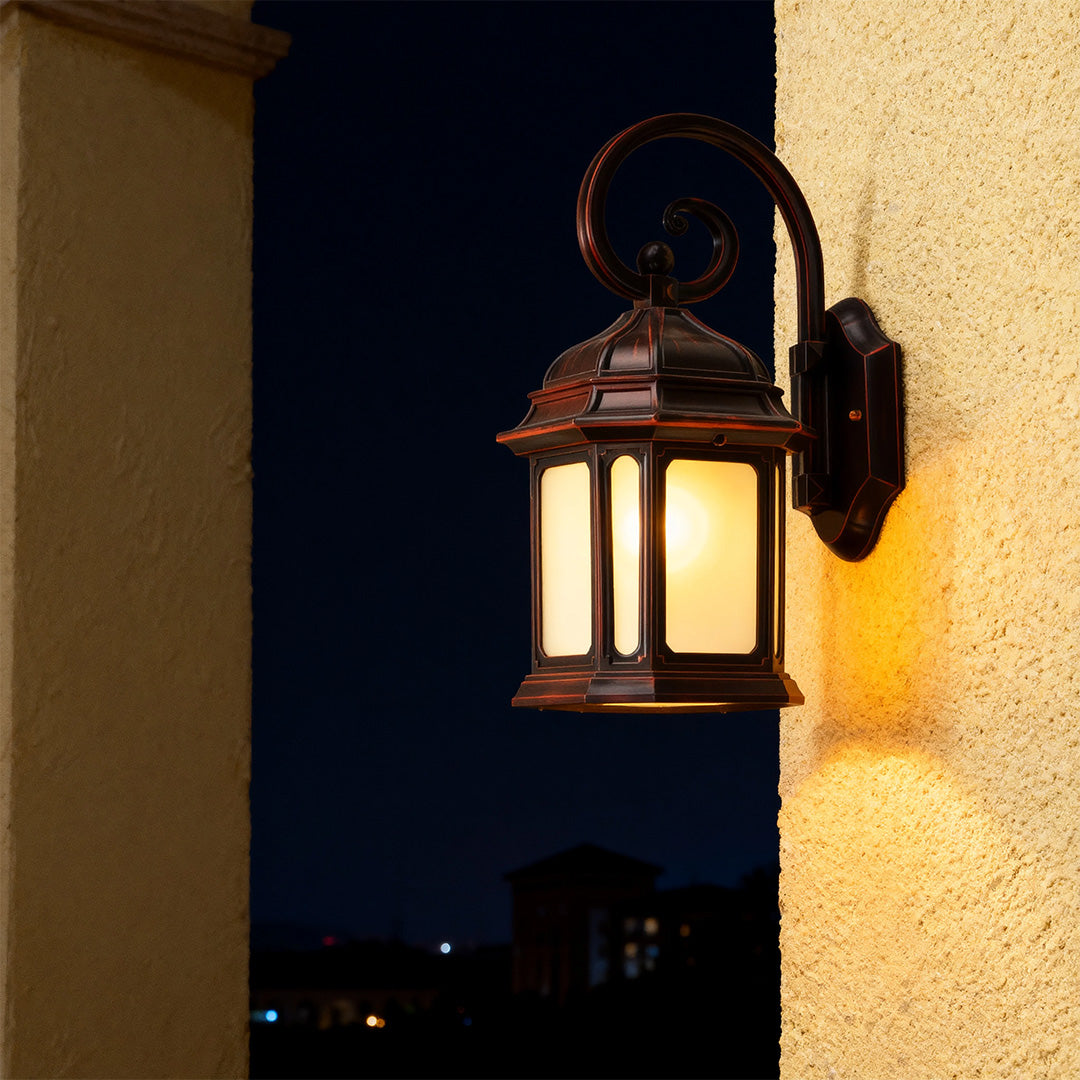 Vintage exterior LED wall light with amber glow illuminating dark entryway against yellow stucco wall