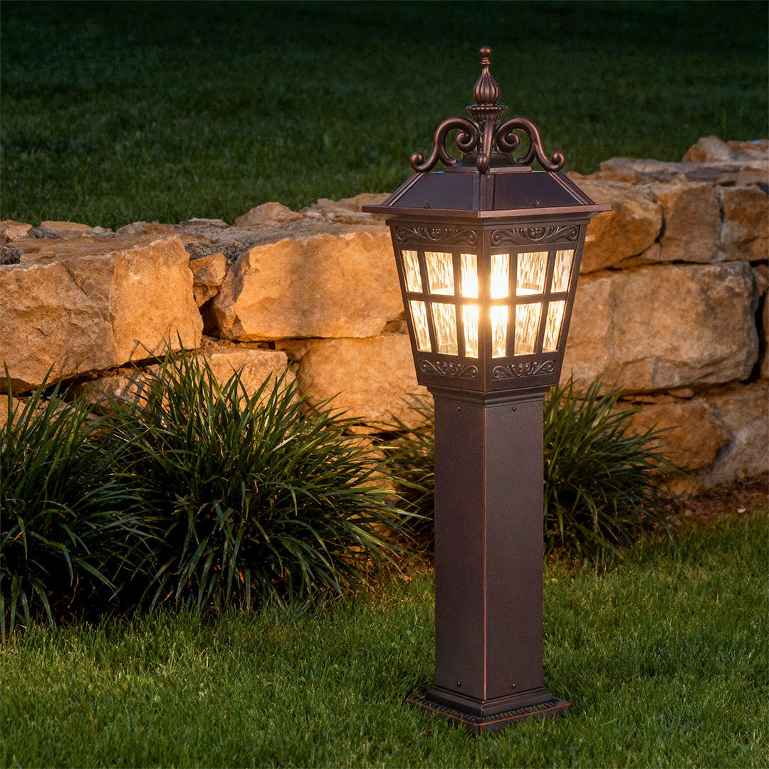 Vintage-style external bollard light illuminating a garden, warm and inviting outdoor lighting