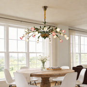 Vintage floral chandelier with pink and white flowers, illuminating a classic dining room.