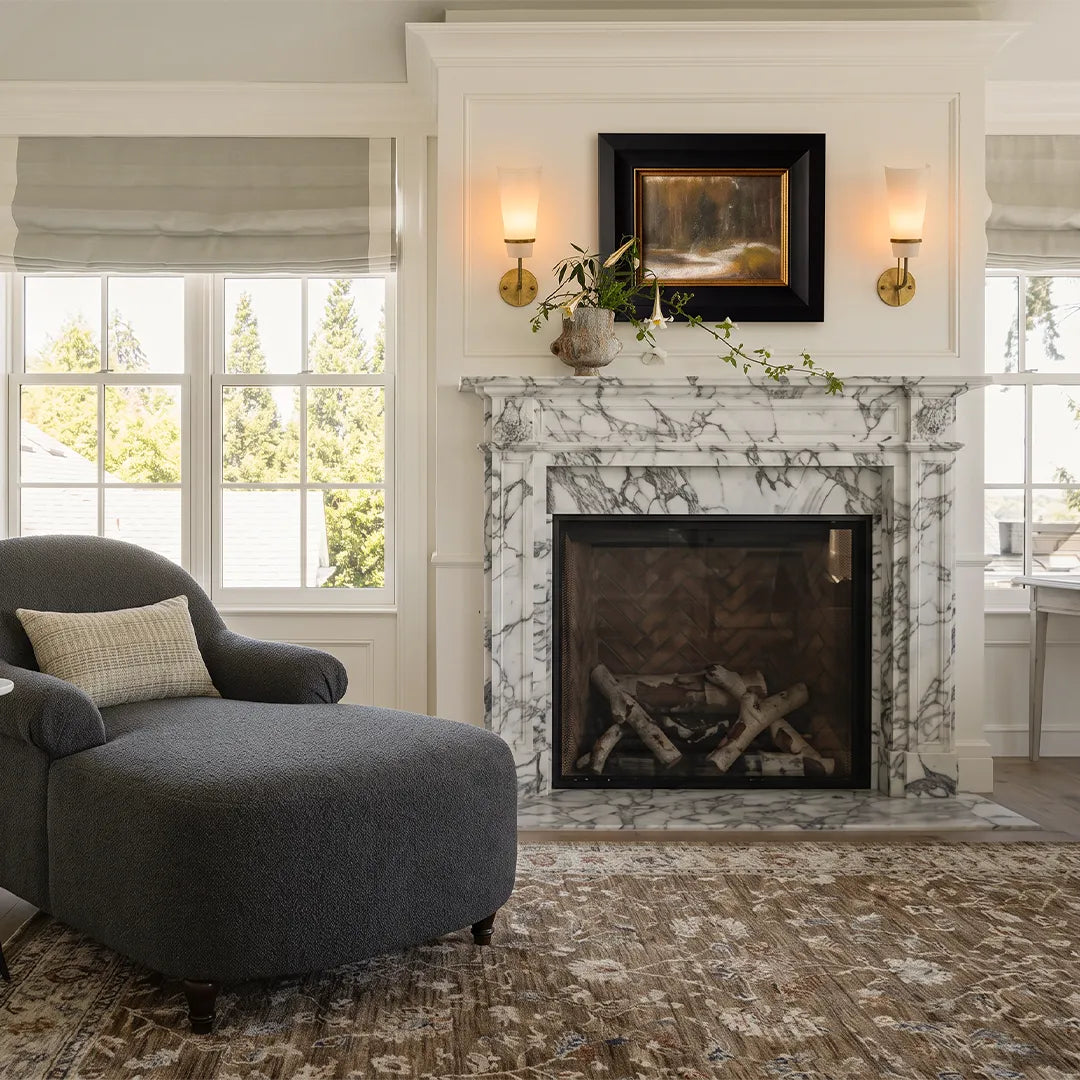 Vintage French wall lights flanking a fireplace in a bright living room with elegant traditional decor.