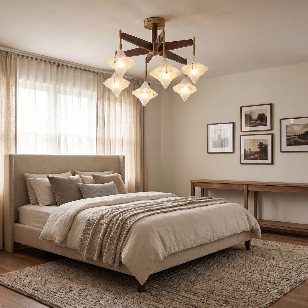 Vintage gold chandelier with crystal-inspired glass shades installed in a cozy bedroom with neutral decor.