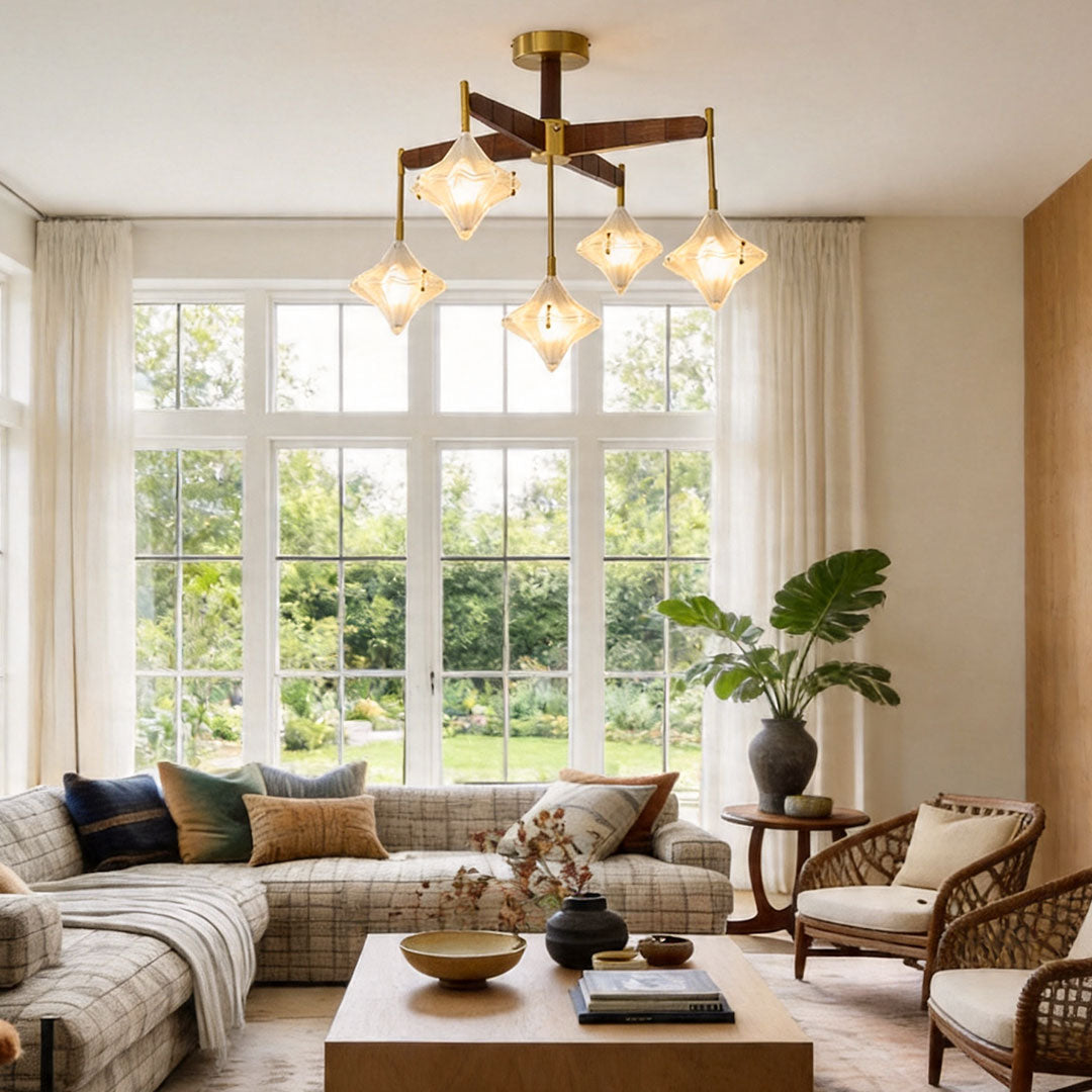 Vintage-style gold chandelier with faceted glass lights illuminating a spacious living room with large windows.