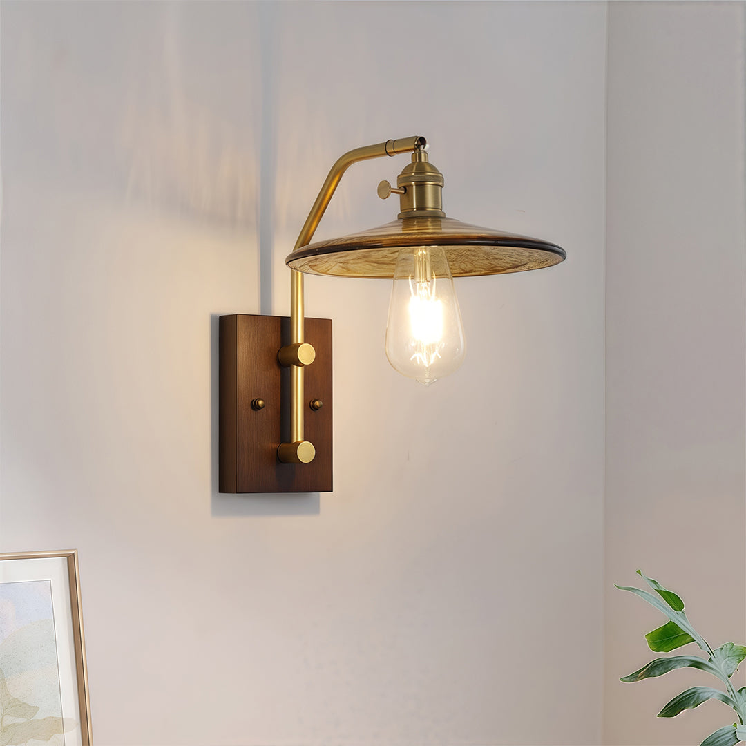 Vintage gold glass wall lights with a wide, spun metal shade and exposed bulb, mounted above a minimalist console table.