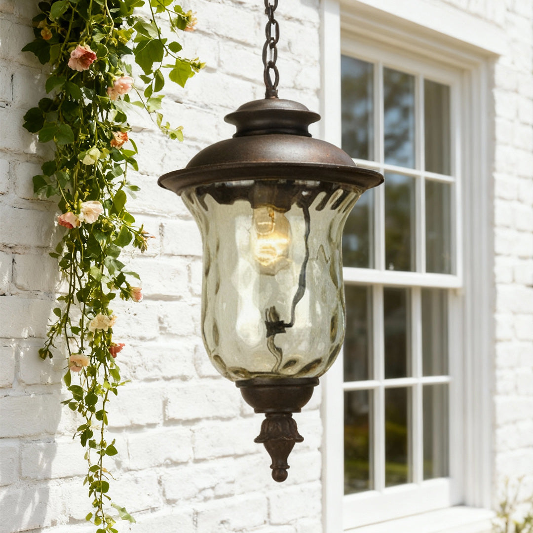 Vintage industrial metal pendant light hanging from white brick overhang with climbing ivy