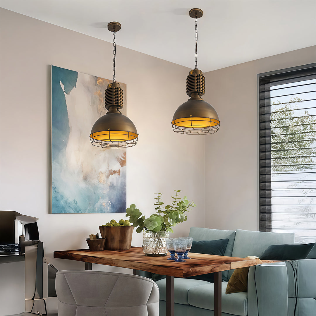 Pair of vintage industrial pendant lighting above dining space complementing coastal-inspired interior with artwork