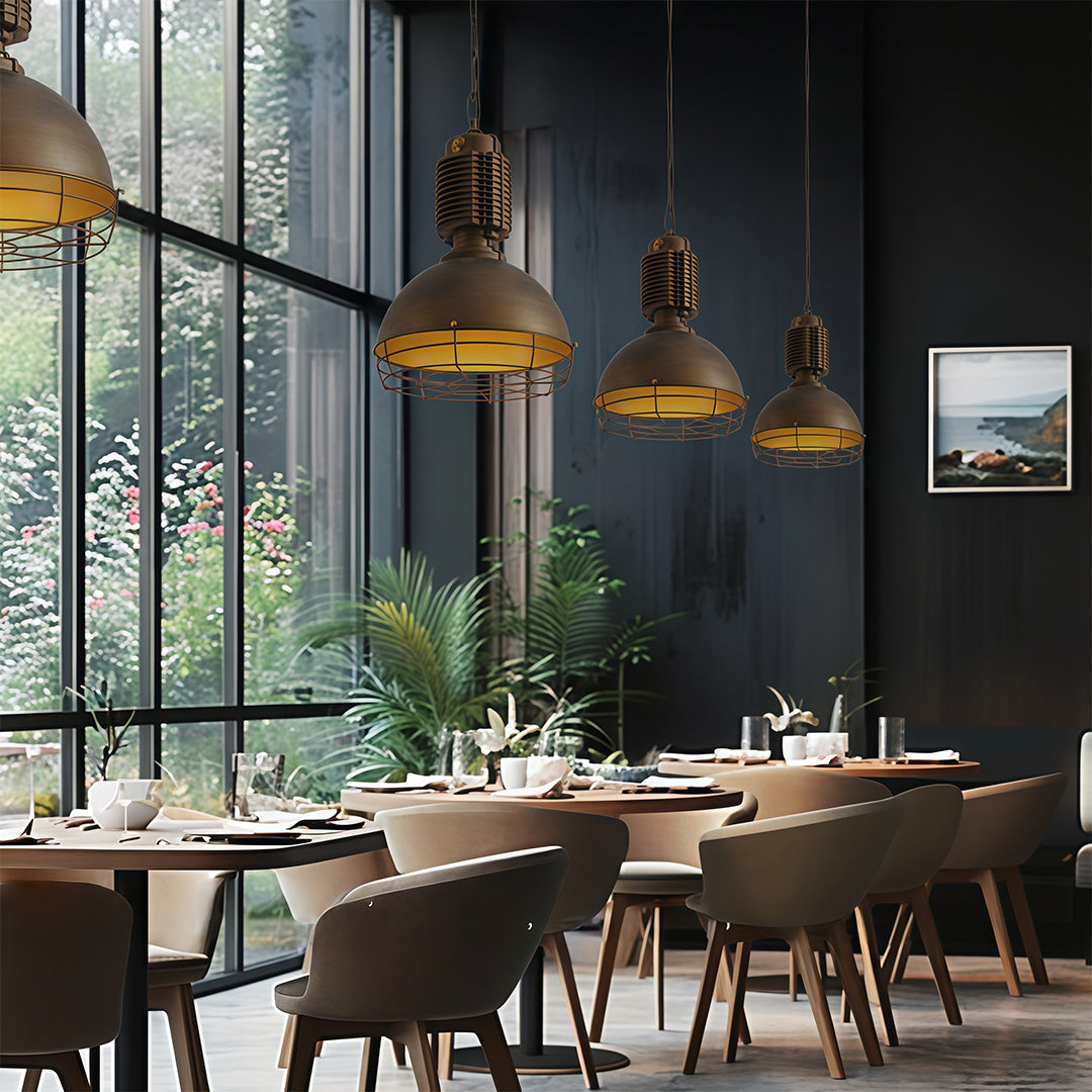 Multiple vintage industrial pendant lighting fixtures over dining area in contemporary restaurant setting with dark decor