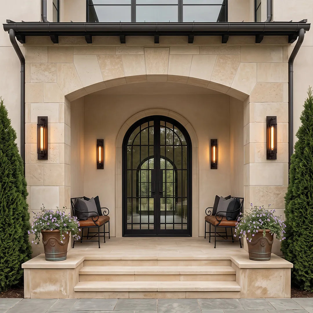 Vintage industrial wall sconces flanking an arched front entry with warm ambient lighting.