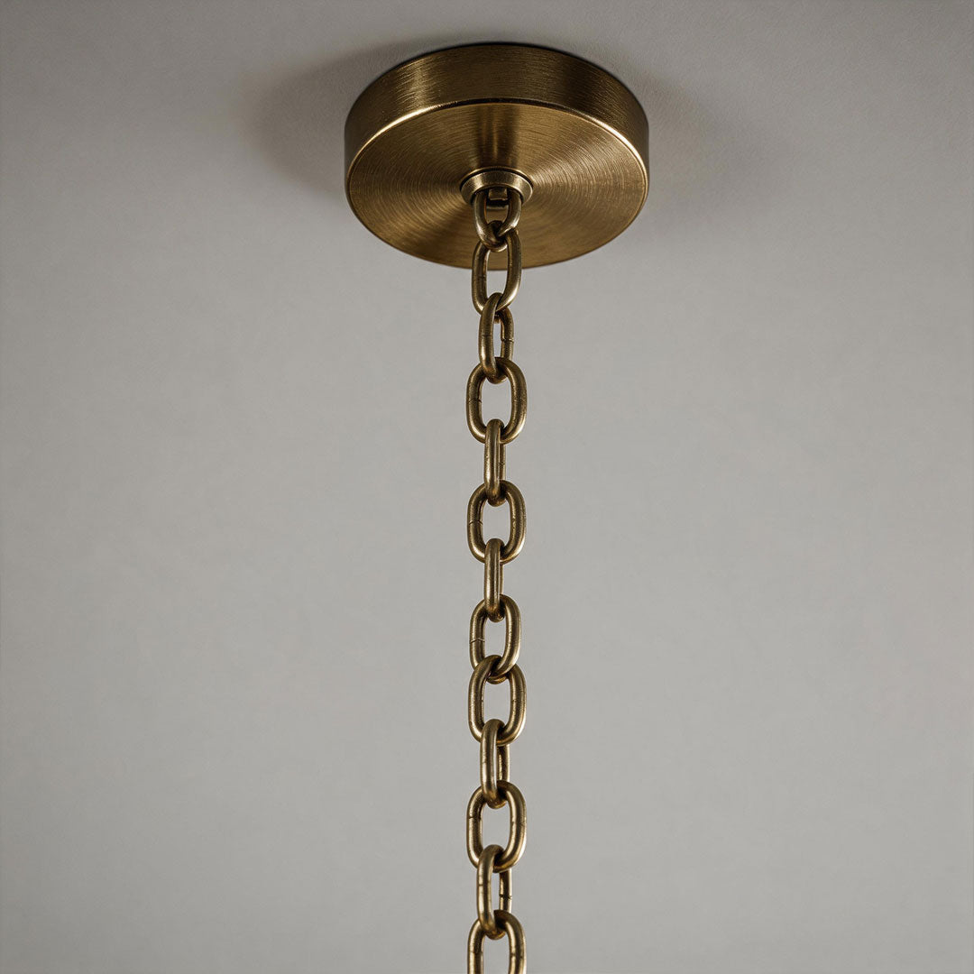 Close-up of the antique brass canopy and hanging chain on a vintage Italian chandelier.
