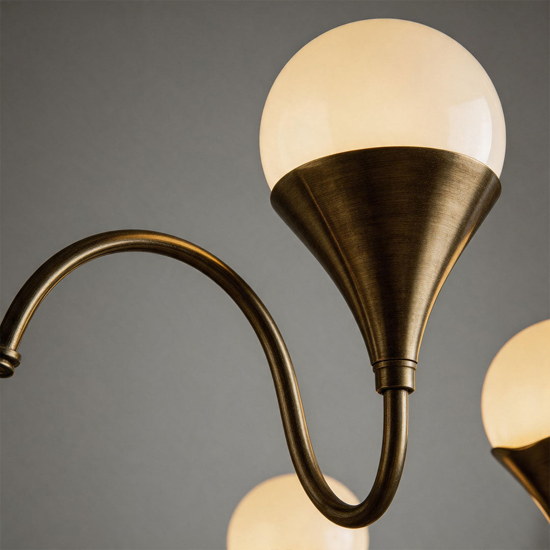 Close-up of a vintage Italian chandelier with an antique brass arm and frosted globe shade.