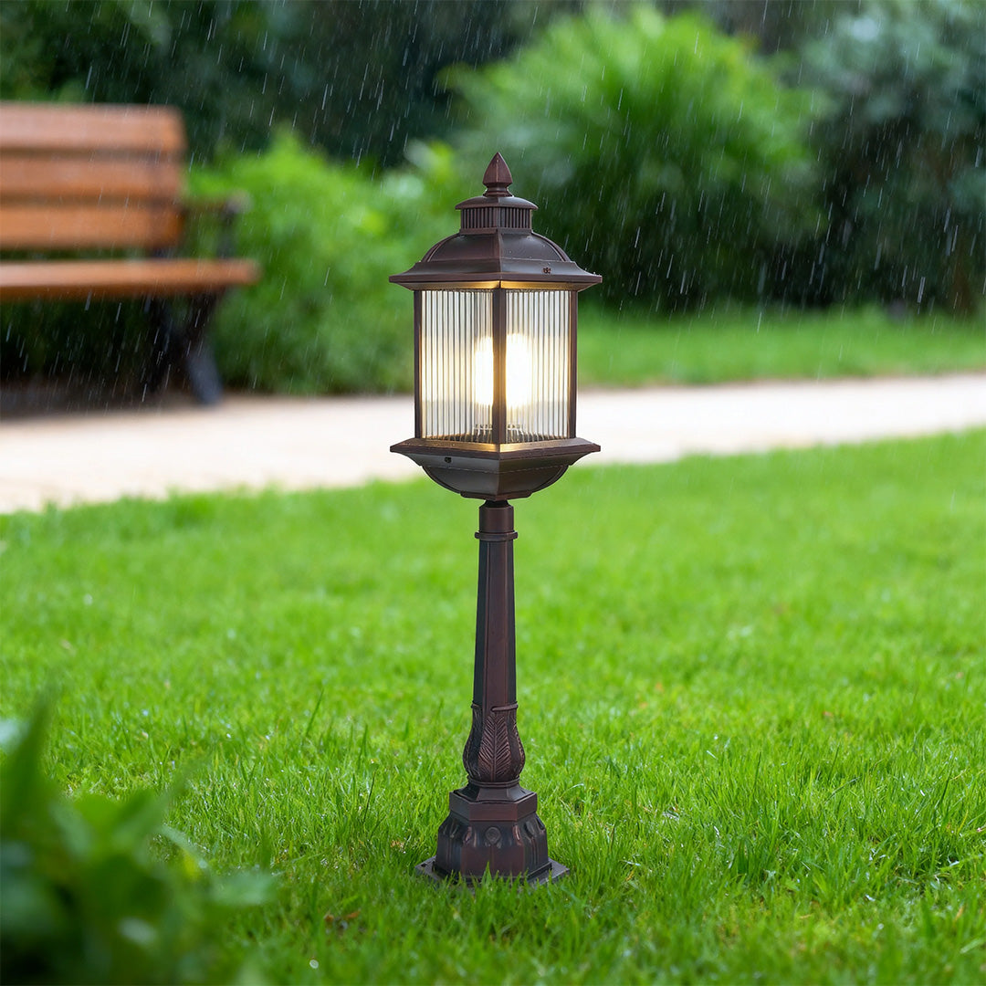 LED post light with vintage lantern design illuminating green lawn area in residential garden setting
