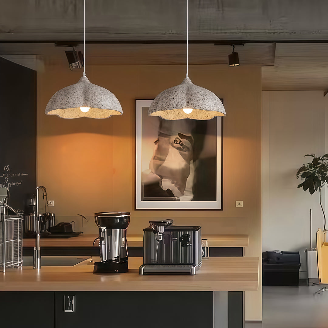 Pair of vintage metal pendant light above café counter, creating warm industrial atmosphere.