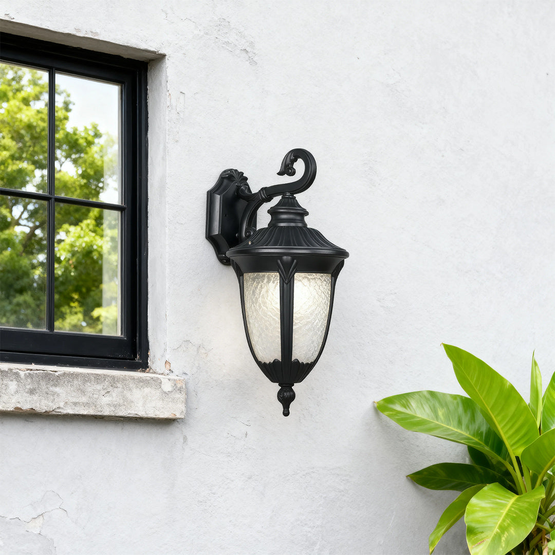 Vintage-style outdoor black wall sconce on a white wall, warm and inviting exterior lighting