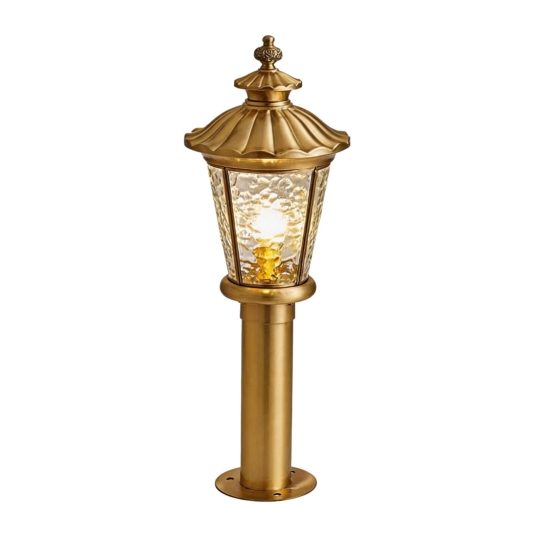 Vintage outdoor bollard light with antique brass finish and warm lantern glow