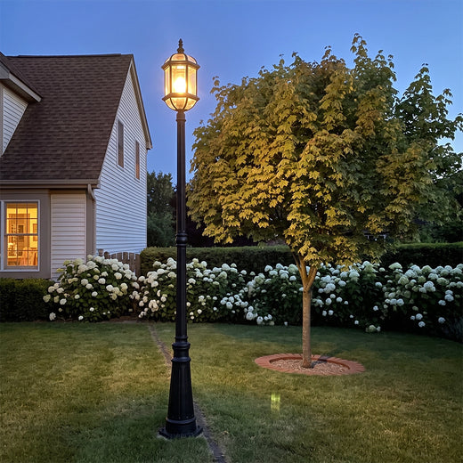Vintage outdoor lamp post with warm glow in landscaped front yard