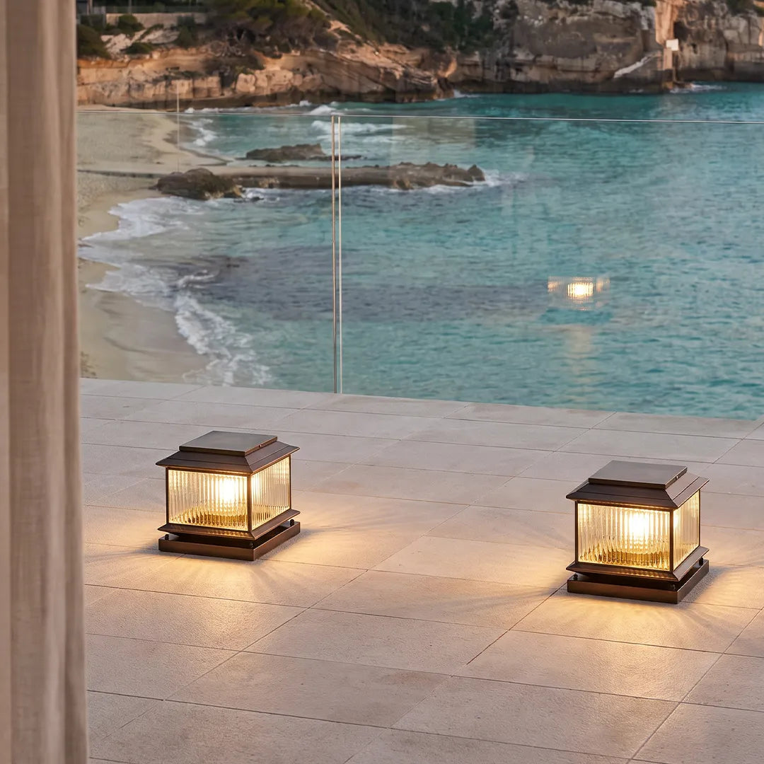 Vintage outdoor pillar lights with warm glow beside swimming pool and patio