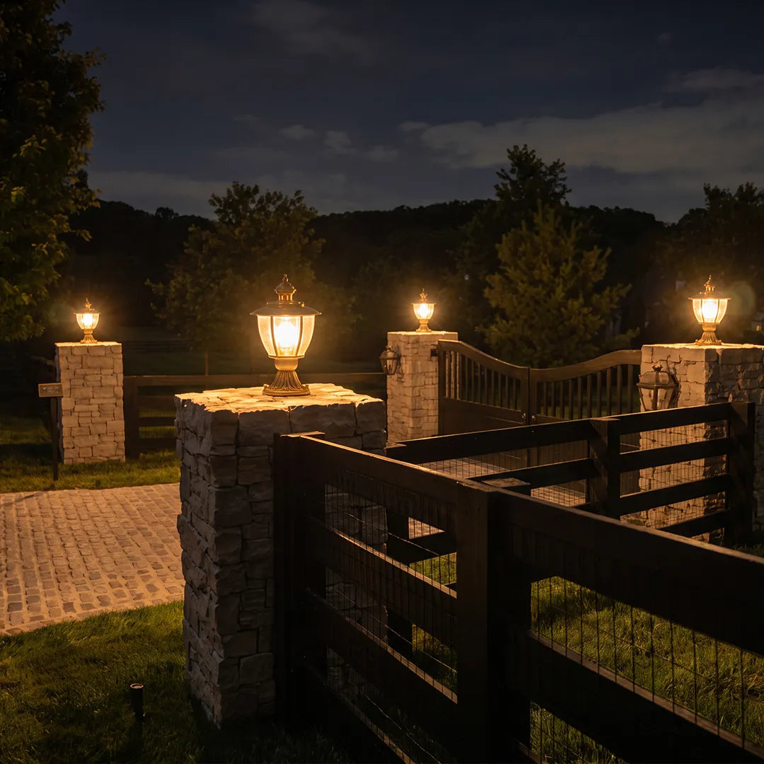 Vintage outdoor pillar lights with warm glow on stone gate columns at night
