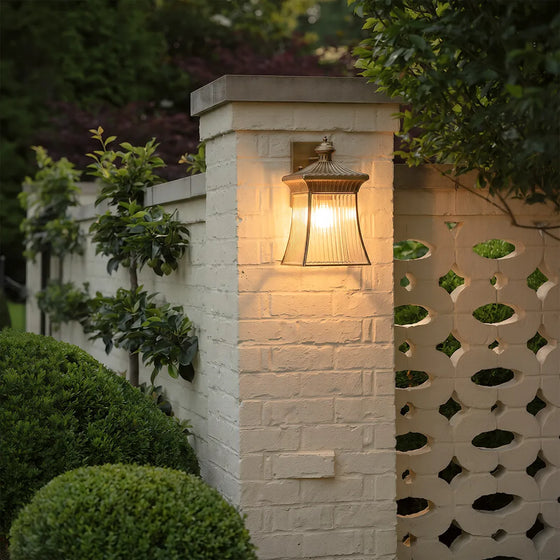 Vintage outdoor wall lantern with warm glow on white brick garden wall