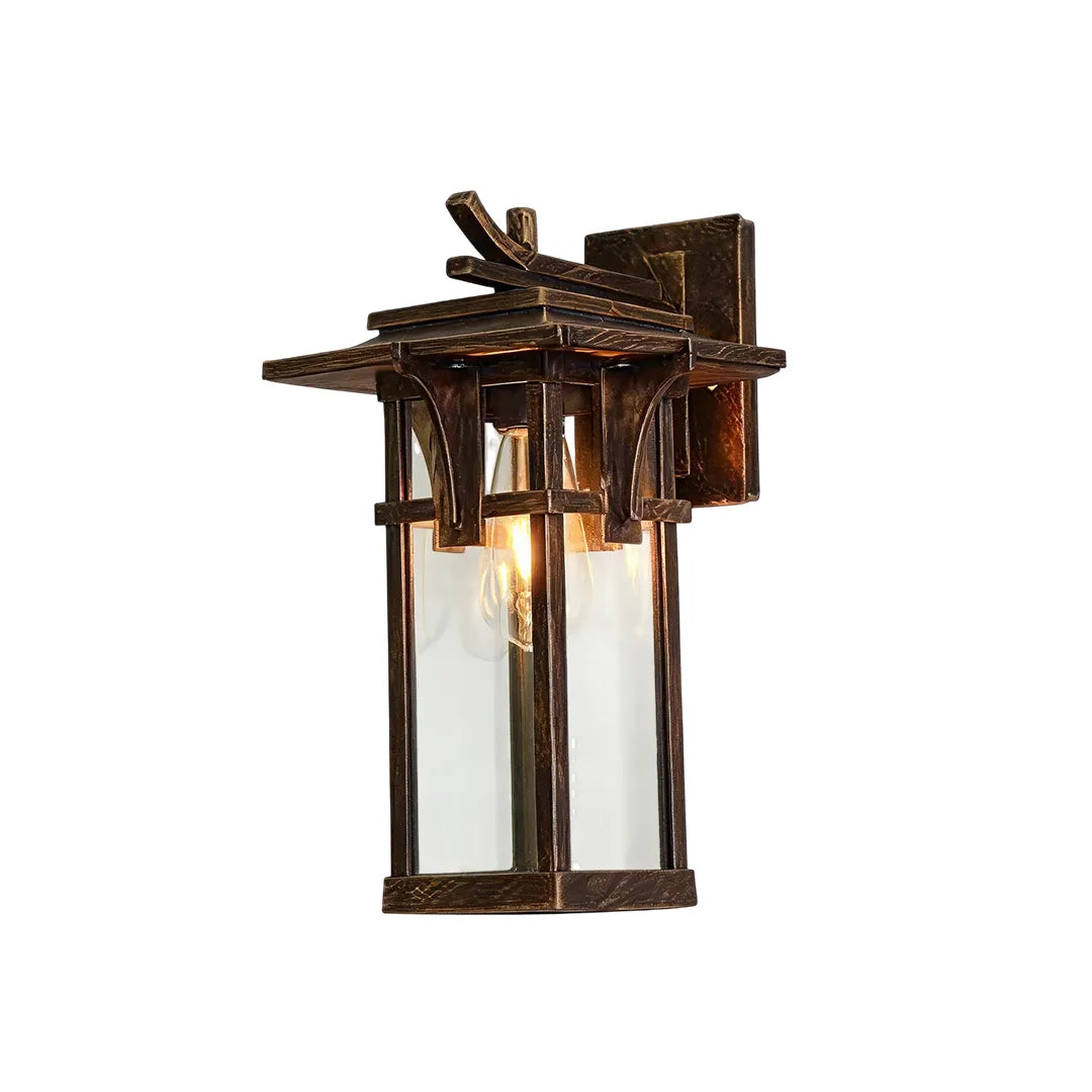 Vintage sconce wall light with an antique bronze finish, ornate frame, and clear glass panels.