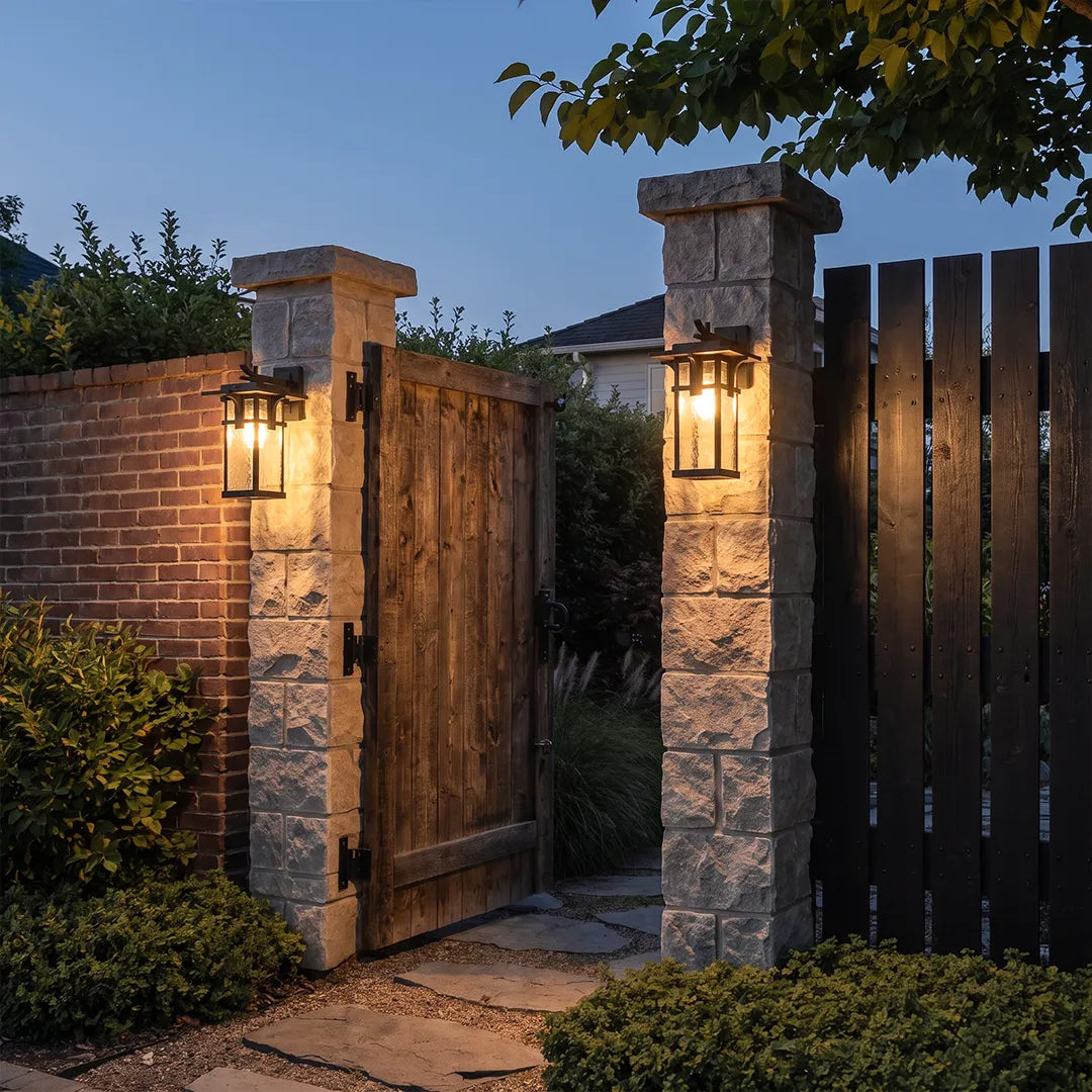 Vintage sconce wall light illuminating a covered brick porch with classic architectural details.