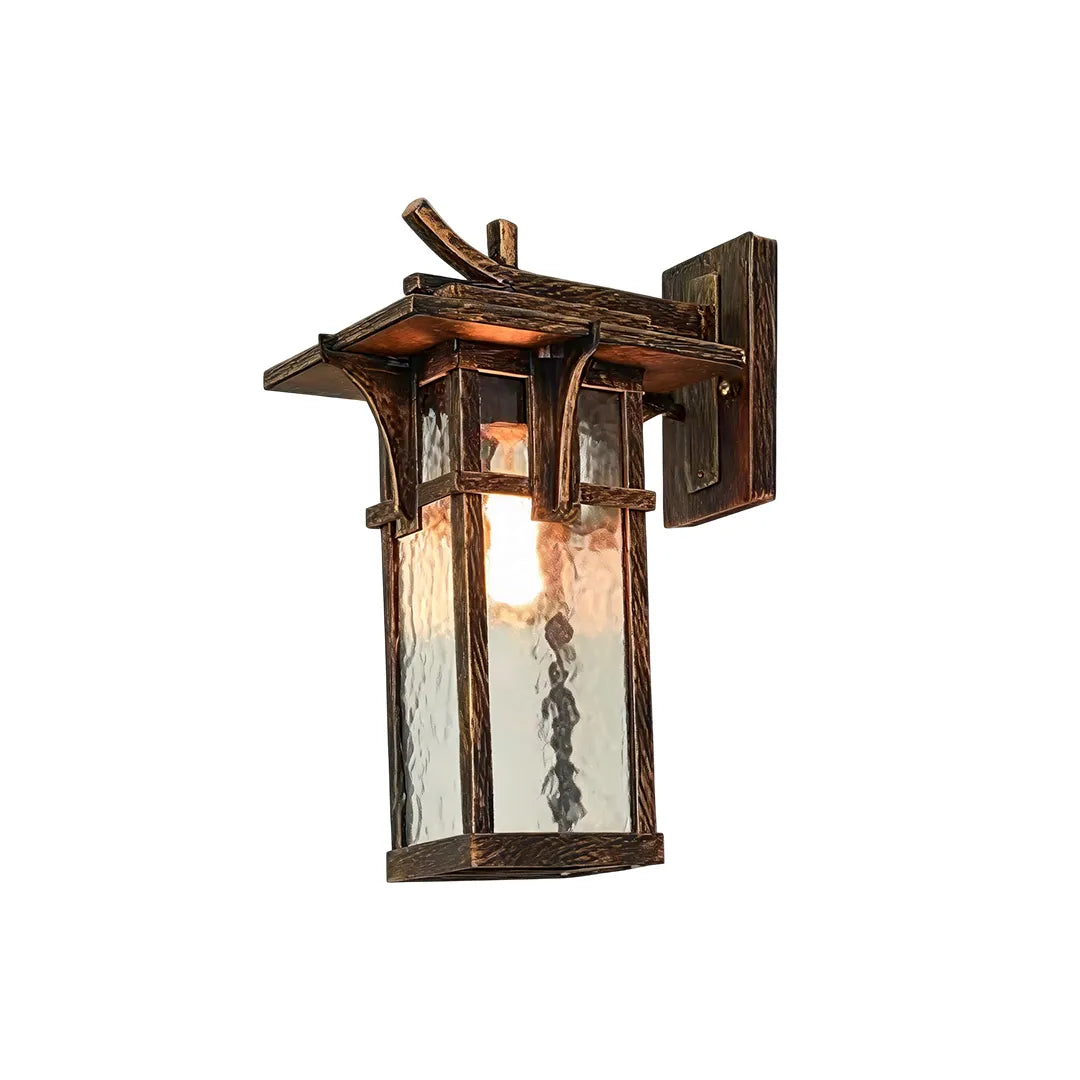 Vintage sconce wall light featuring decorative bronze metalwork and a warm illuminated lantern design.