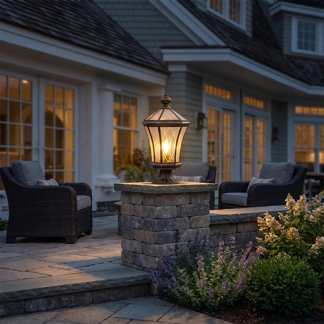 Vintage solar pillar lantern illuminating garden patio beside outdoor lounge chairs
