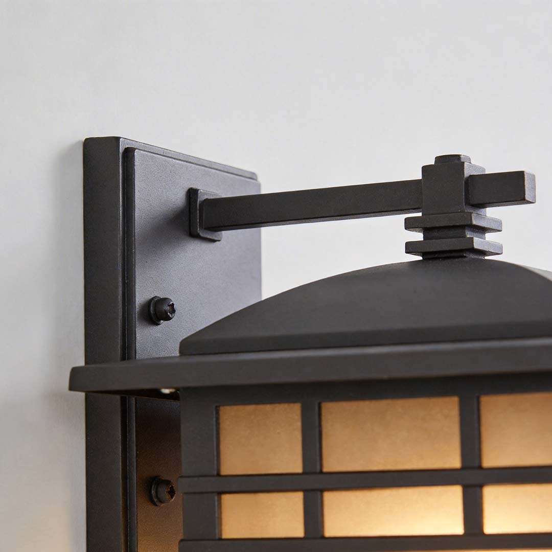 Vintage wall lantern with a black frame, providing soft light in a cozy outdoor setting.