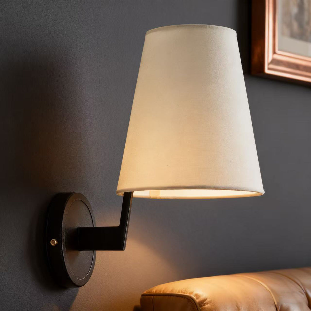Vintage wall lights providing ambient lighting on charcoal wall with elegant tapered shade and wooden arm detail