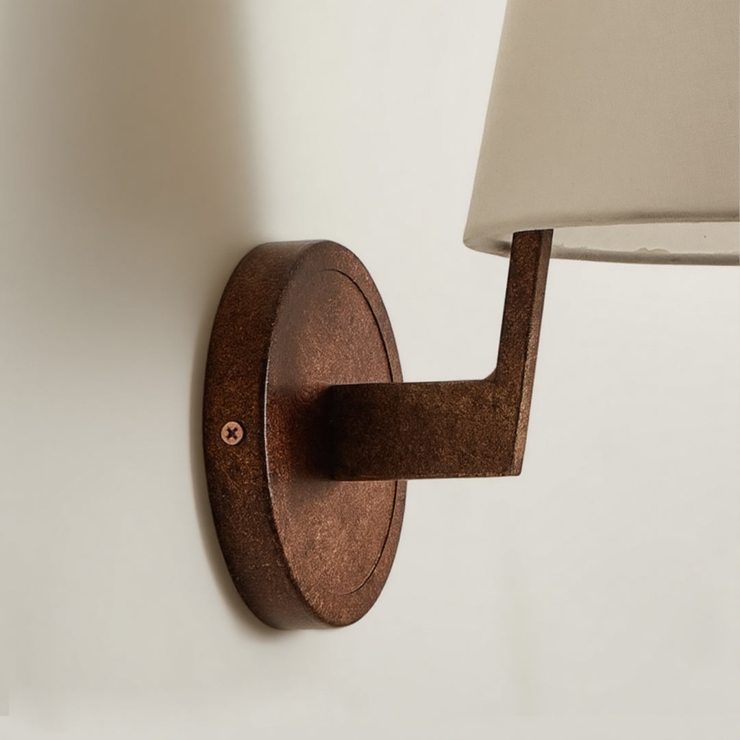 Close-up of vintage wall lights showing curved wooden arm bracket detail and fabric shade mounting hardware
