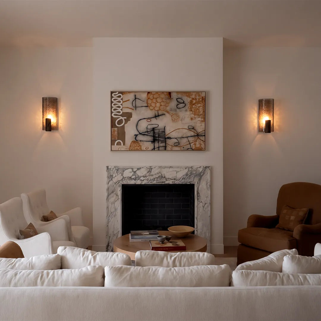 Vintage wall sconce light pair mounted on both sides of a fireplace in a cozy living room.