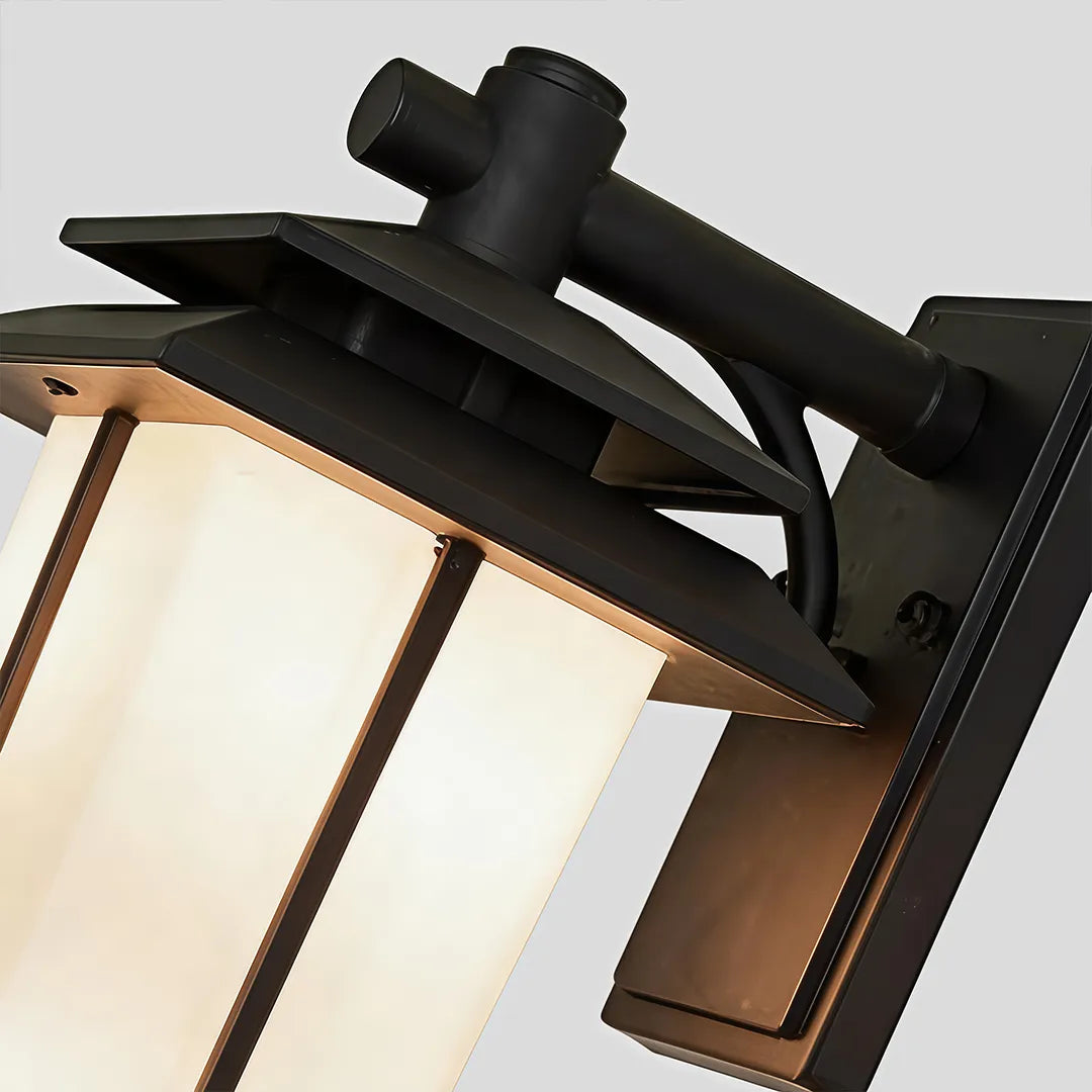 Vintage wall sconce light fixtures close-up showing the black metal frame and frosted glass shade.
