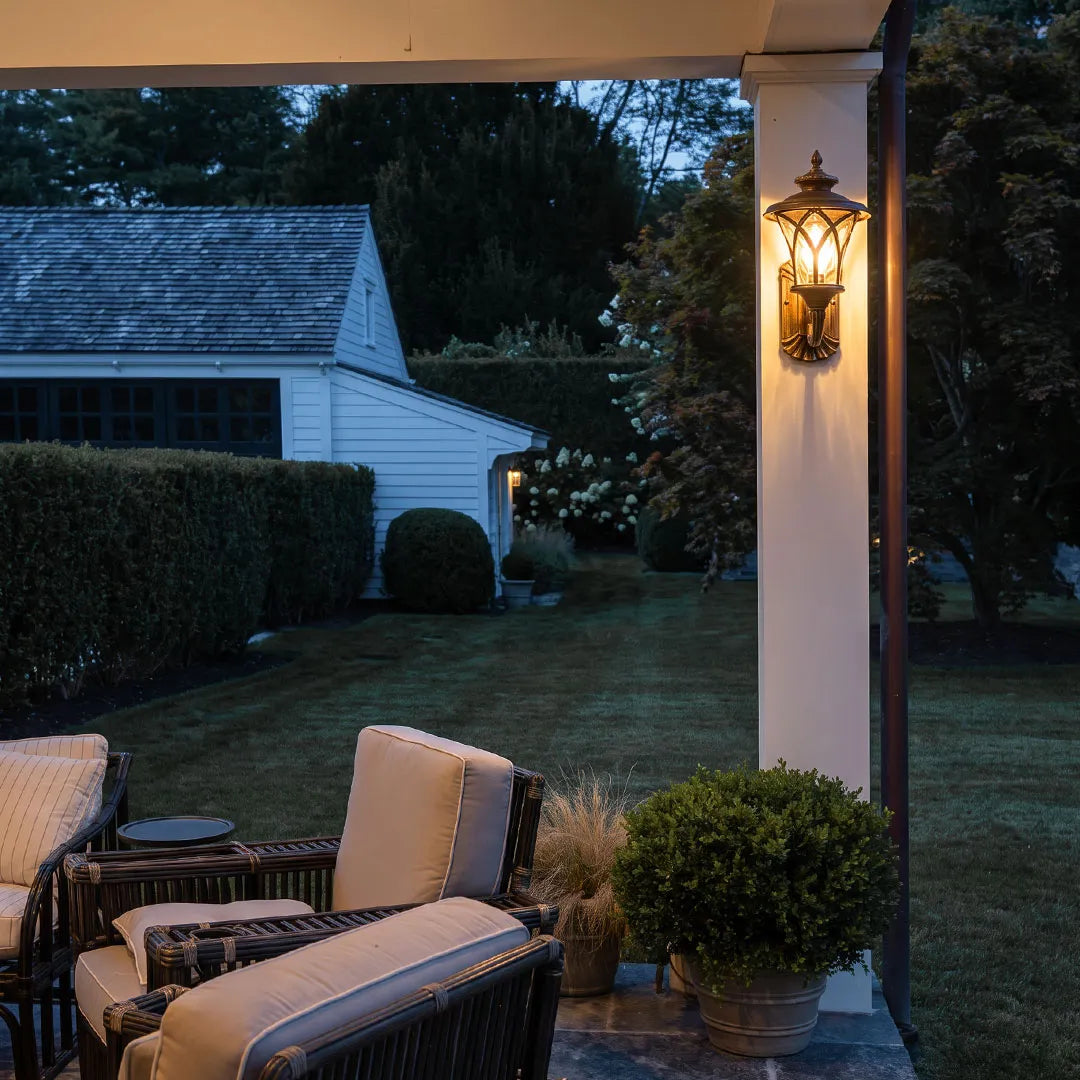 Vintage wall sconce light fixtures mounted on a patio column beside an outdoor seating area.