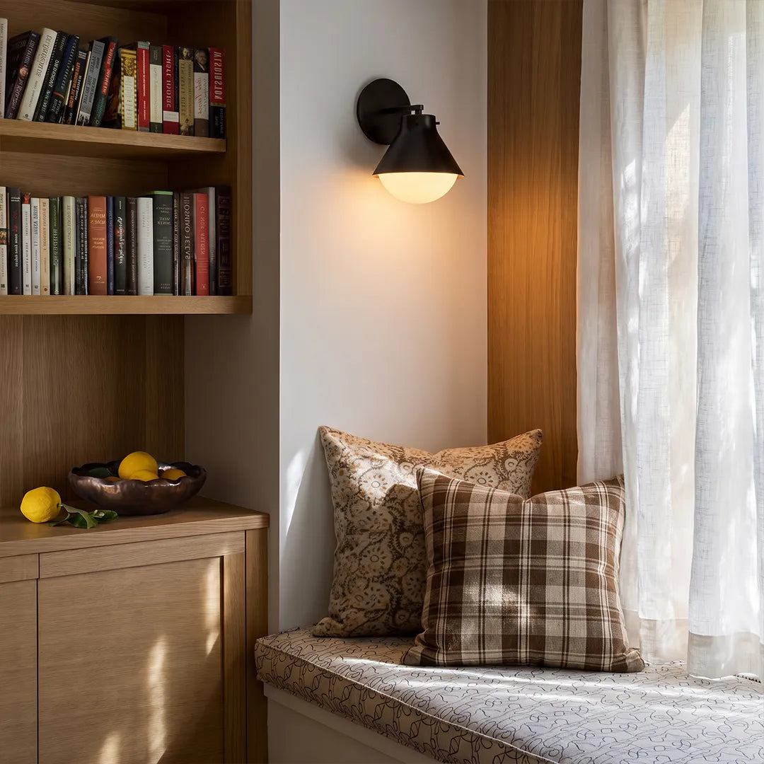 Vintage wall sconce lights in black finish above a reading nook with built-in shelving and a cozy bench seat.