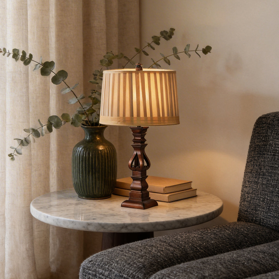 Vintage wood table lamp with a striped shade, illuminating a side table with decor.